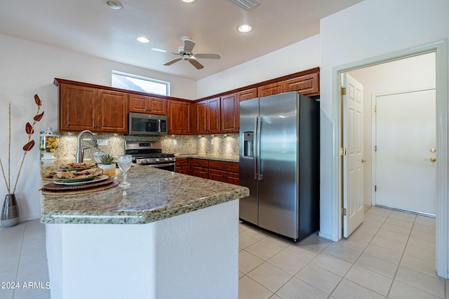 kitchen with light tile patterned floors, dark stone countertops, appliances with stainless steel finishes, ceiling fan, and decorative backsplash