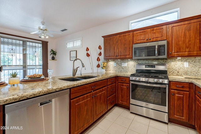 kitchen featuring tasteful backsplash, sink, light stone counters, and stainless steel appliances