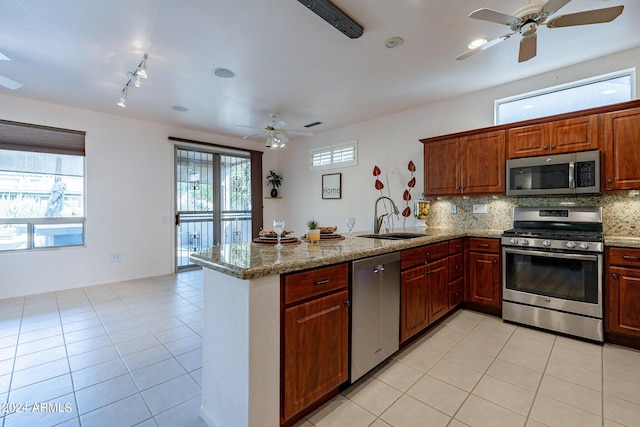 kitchen with tasteful backsplash, appliances with stainless steel finishes, sink, and kitchen peninsula