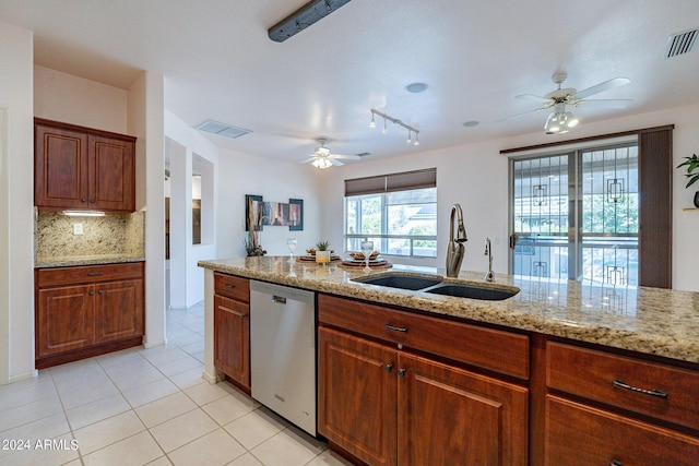 kitchen with light tile patterned flooring, sink, backsplash, stainless steel dishwasher, and light stone counters