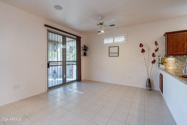 tiled spare room featuring ceiling fan