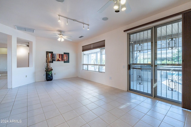 unfurnished room featuring light tile patterned flooring, ceiling fan, and track lighting