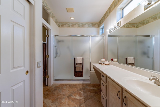 bathroom with vanity and a shower with door