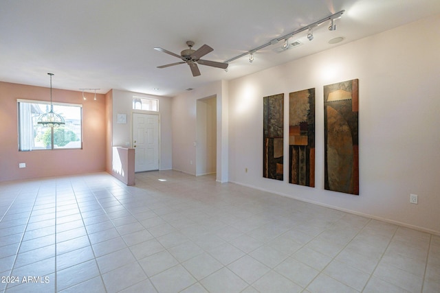 tiled empty room with rail lighting and ceiling fan