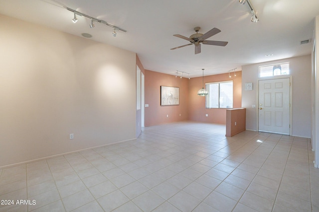 tiled empty room with track lighting and ceiling fan