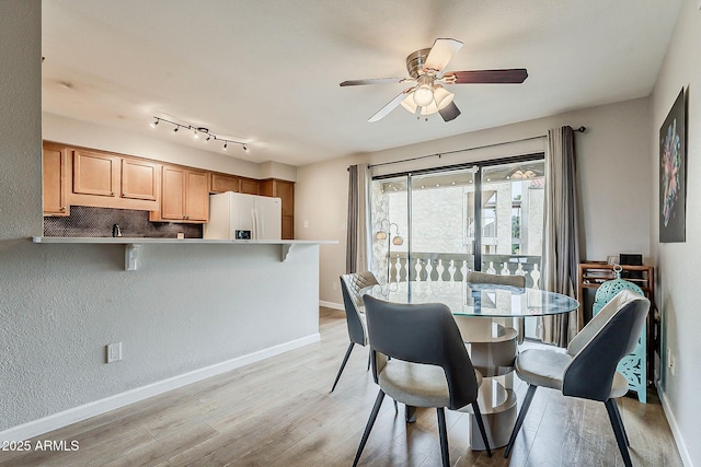 dining room with light wood-style flooring, baseboards, and ceiling fan