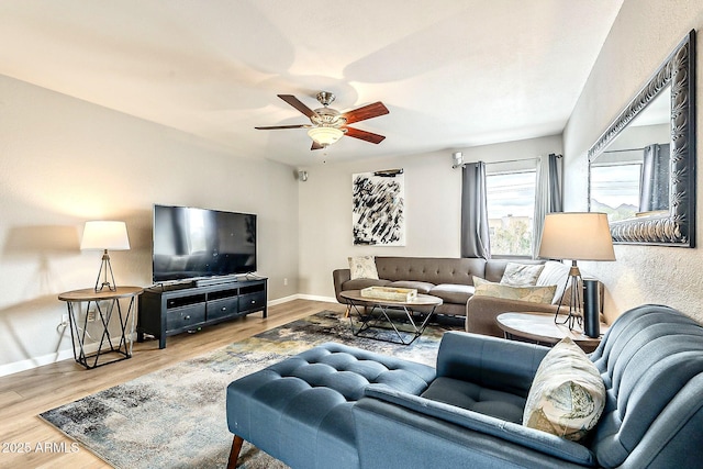 living room with baseboards, ceiling fan, and wood finished floors