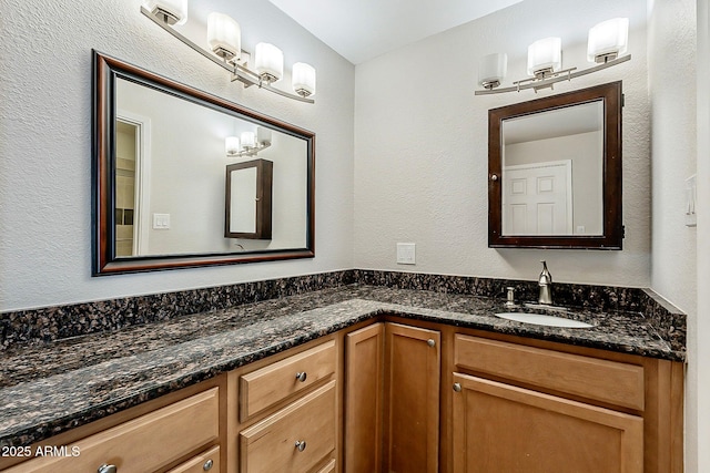 bathroom featuring vanity and a textured wall