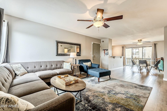 living room with baseboards, wood finished floors, and ceiling fan