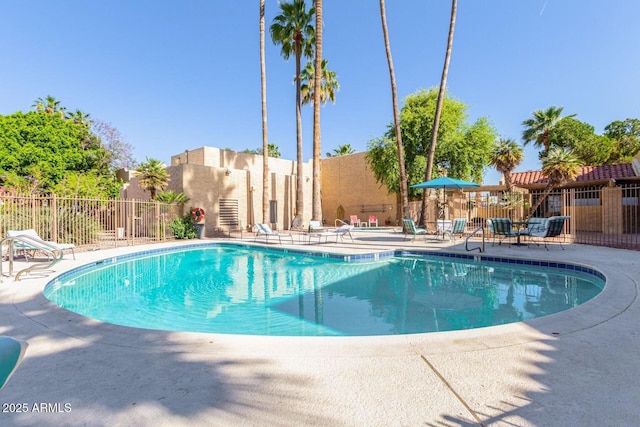 pool with a patio and fence