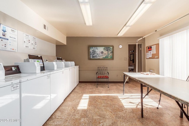 shared laundry area with visible vents, baseboards, and washing machine and dryer