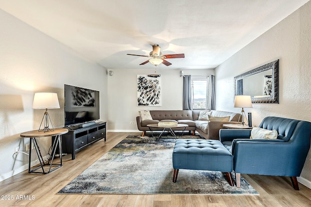 living room with baseboards, ceiling fan, and wood finished floors