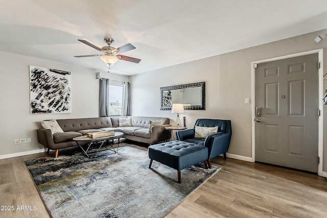 living room with light wood-style flooring, baseboards, and a ceiling fan