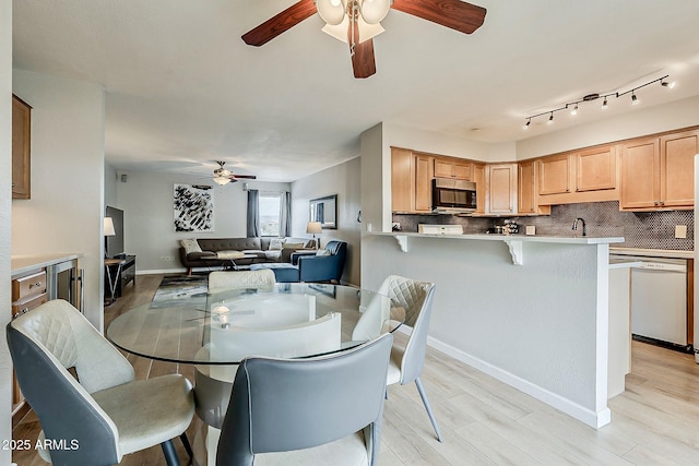 dining area with baseboards, light wood-type flooring, and ceiling fan