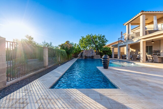 view of pool featuring pool water feature, a patio, and ceiling fan