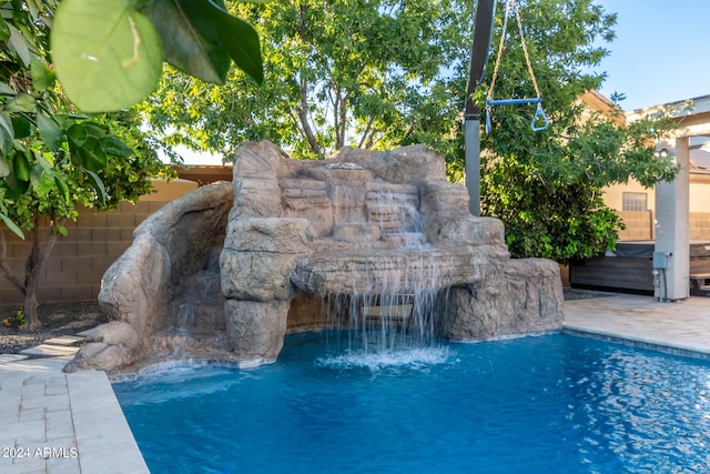 view of swimming pool with pool water feature