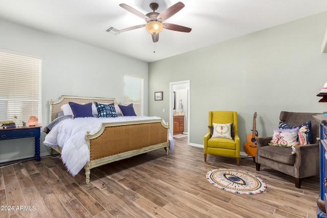 bedroom with ensuite bathroom, hardwood / wood-style flooring, and ceiling fan