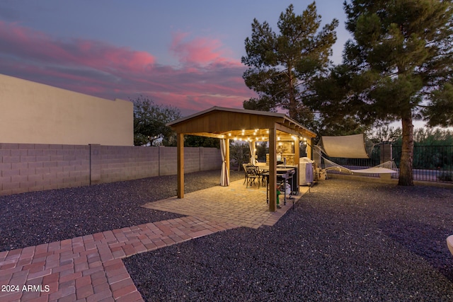 yard at dusk featuring a patio