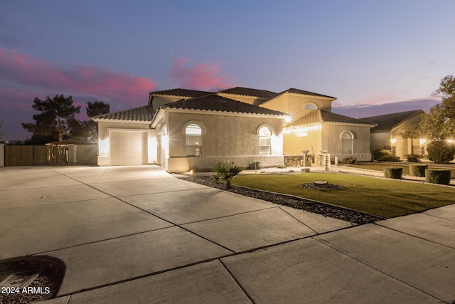 mediterranean / spanish-style house with a garage and a lawn