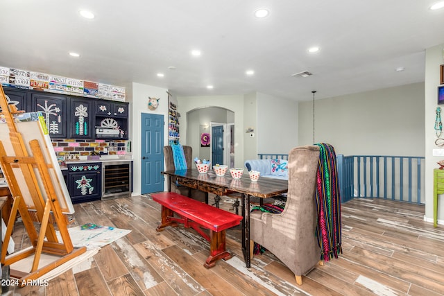 dining space featuring hardwood / wood-style flooring and beverage cooler