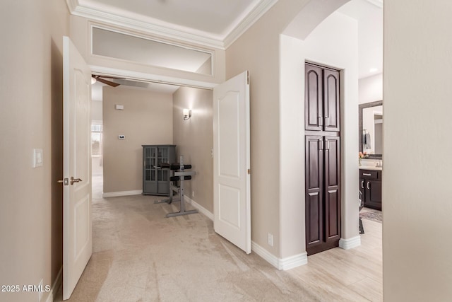 hallway featuring light colored carpet and ornamental molding