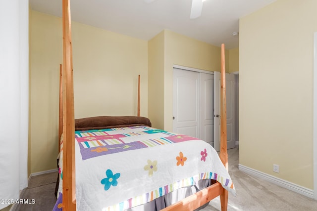 carpeted bedroom featuring ceiling fan and a closet