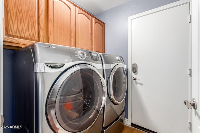 laundry area featuring washer and clothes dryer and cabinets