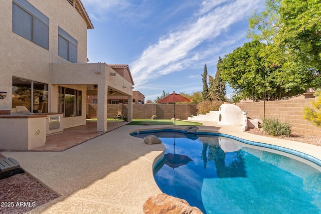 view of swimming pool with exterior kitchen and a patio area