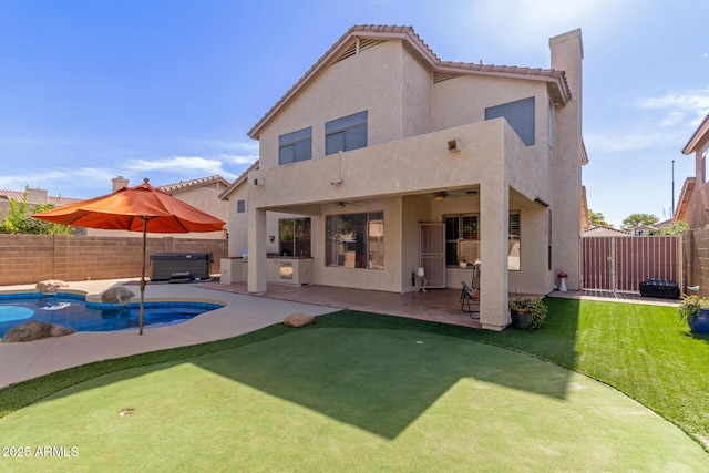 rear view of house with a patio area, a hot tub, and ceiling fan