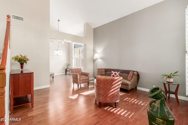 living room with hardwood / wood-style flooring and high vaulted ceiling