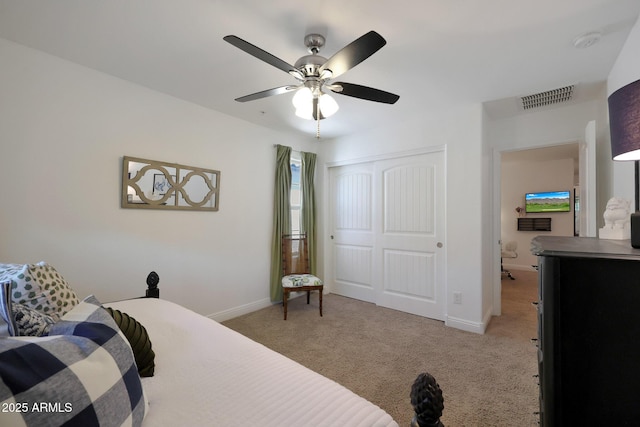 bedroom featuring light carpet, visible vents, baseboards, and a closet
