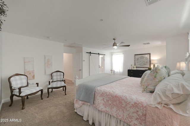 bedroom featuring a barn door, light carpet, visible vents, and ceiling fan