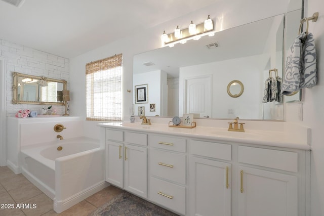 full bathroom featuring tile patterned floors, a garden tub, double vanity, and a sink