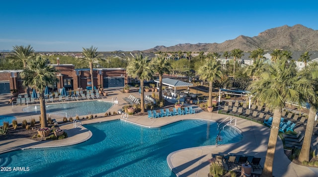 community pool featuring a patio, fence, and a mountain view