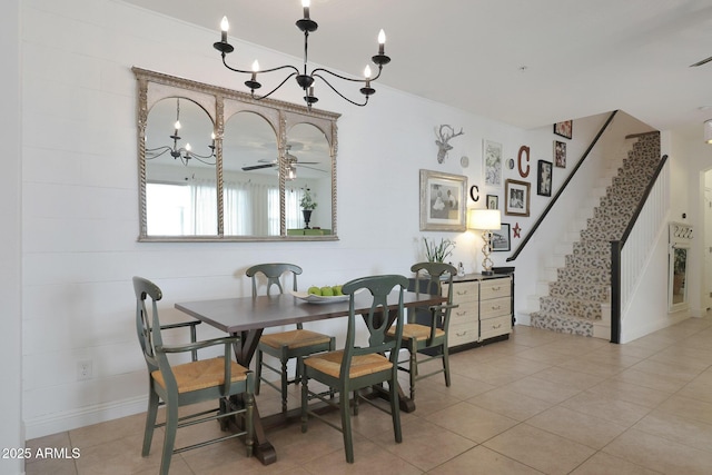 dining room with light tile patterned floors, stairs, and ceiling fan with notable chandelier
