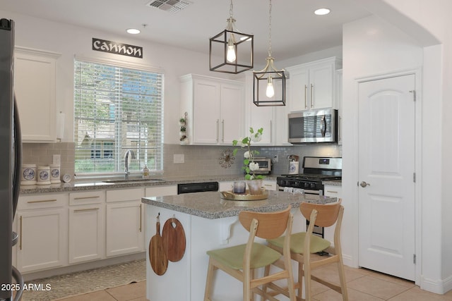 kitchen with visible vents, white cabinets, appliances with stainless steel finishes, and a sink