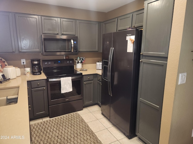 kitchen featuring appliances with stainless steel finishes, gray cabinets, and light tile patterned flooring