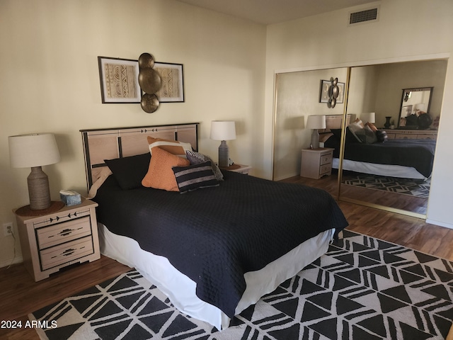 bedroom with dark hardwood / wood-style floors and a closet