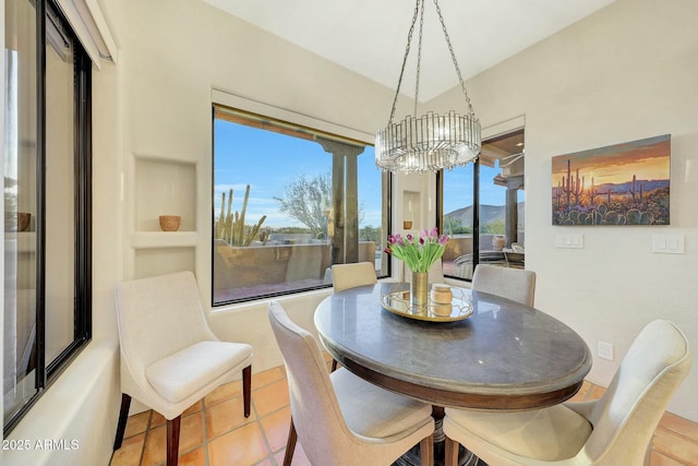 dining room featuring a mountain view, light tile patterned floors, and a chandelier