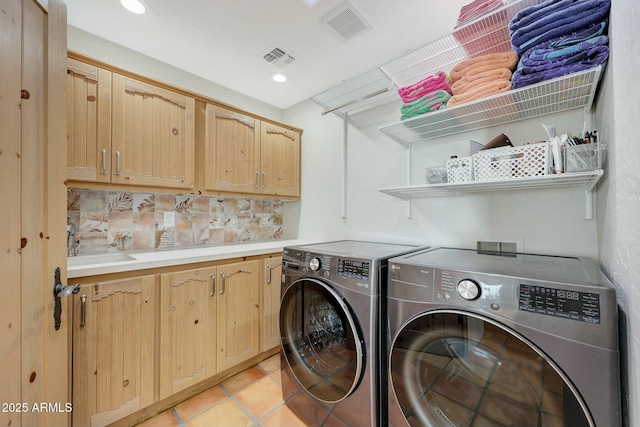 washroom with cabinets, separate washer and dryer, and light tile patterned floors