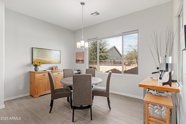 dining room with light hardwood / wood-style flooring and a chandelier