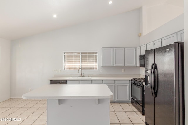 1371 W Gary Dr, Chandler, AZ 85224 - kitchen with black appliances, light tile patterned flooring, light countertops, a kitchen island, and vaulted ceiling