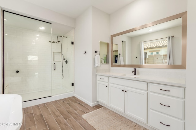 bathroom featuring a shower with door and vanity