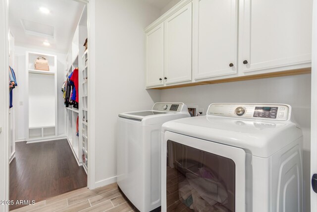 washroom featuring cabinets, separate washer and dryer, and light hardwood / wood-style flooring