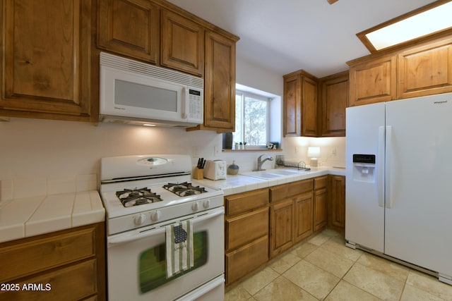 2273 Lindbergh Rd, Overgaard, AZ 85933 - kitchen featuring white appliances, a sink, tile counters, brown cabinetry, and light tile patterned flooring