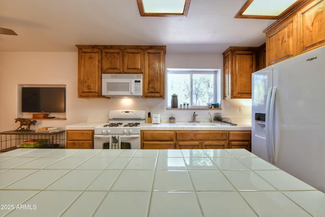 2273 Lindbergh Rd, Overgaard, AZ 85933 - kitchen featuring white appliances, brown cabinetry, a sink, and tile counters