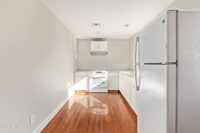 kitchen with white cabinets, white appliances, light hardwood / wood-style floors, and sink