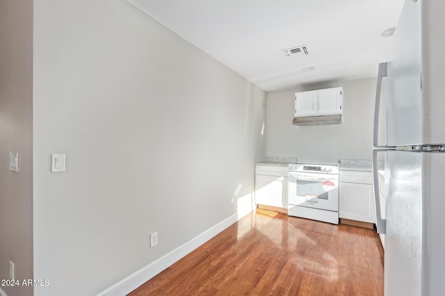 kitchen with white cabinets, light wood-type flooring, and white appliances