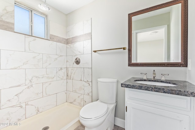 bathroom featuring tiled shower, vanity, and toilet