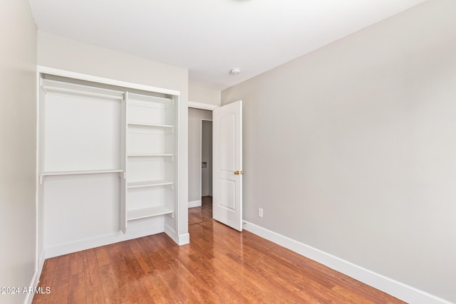 unfurnished bedroom with wood-type flooring and a closet